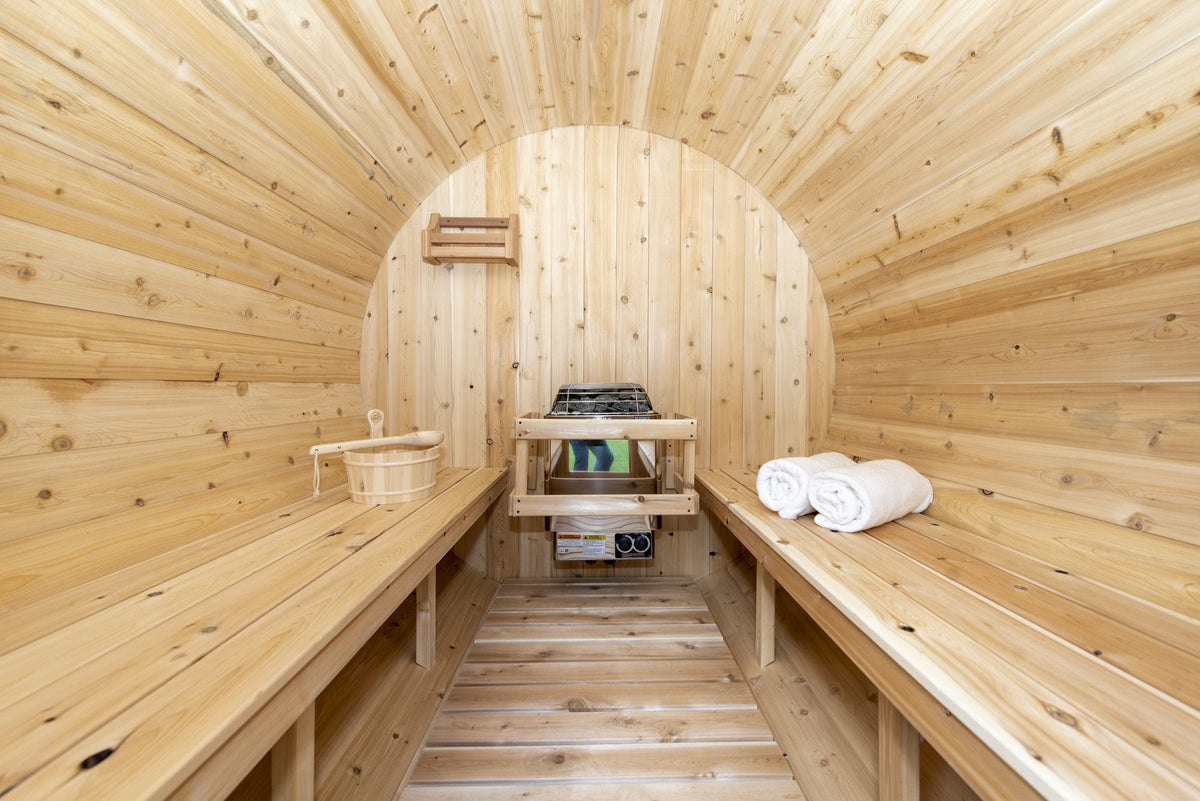 Barrel sauna interior with heater, bucket and towels